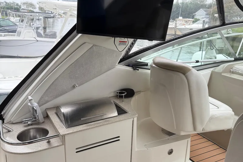 Slide: The Image of 2008 Sea Ray 330 Sundancer cockpit with sink, grill, and seating, docked at marina. - 24