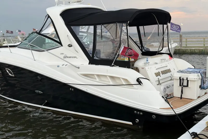 Slide: The Image of 2008 Sea Ray 330 Sundancer docked, featuring sleek design and black canvas cover. - 6