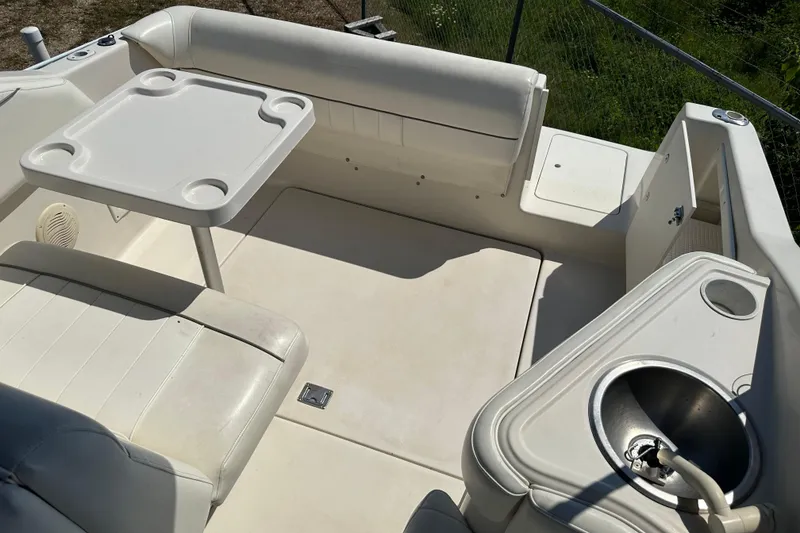 Slide: The Image of 1999 Monterey 262 Cruiser boat interior with seating, table, and sink. - 11