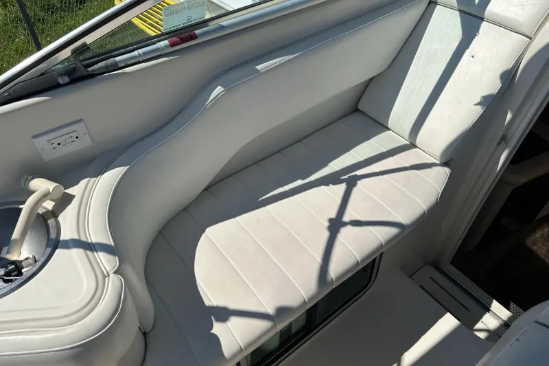 Slide: The Image of 1999 Monterey 262 Cruiser interior with white seating and built-in cup holder. - 6
