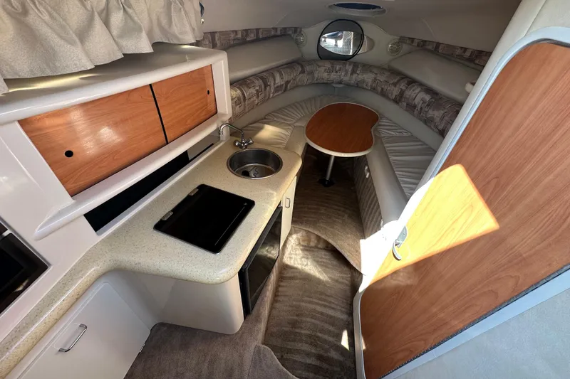 Slide: The Image of 1999 Monterey 262 Cruiser interior with kitchenette, sink, and seating area. - 7