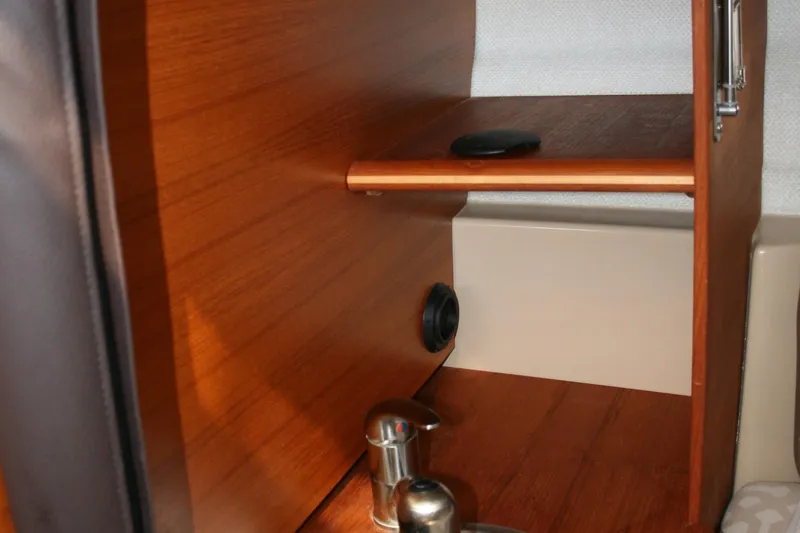 Slide: The Image of Interior of 2018 Ranger Tugs R-23 boat, featuring wooden cabinetry and stainless steel fixtures. - 18