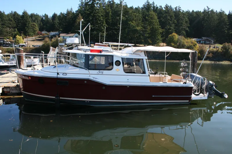 Slide: The Image of 2018 Ranger Tugs R-23 boat docked in a scenic marina setting. - 2
