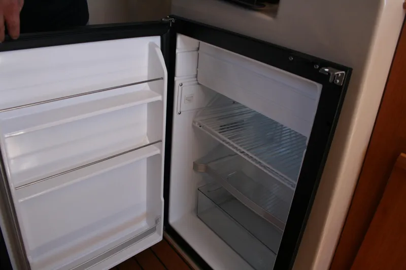 Slide: The Image of Open refrigerator inside 2018 Ranger Tugs R-23 boat, showcasing interior shelves and storage. - 25