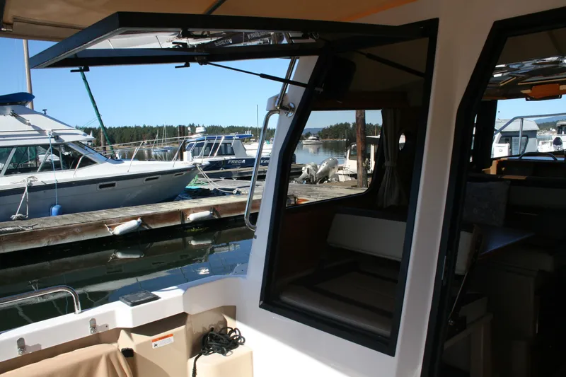 Slide: The Image of 2018 Ranger Tugs R-23 boat interior with open door, docked at marina. - 29