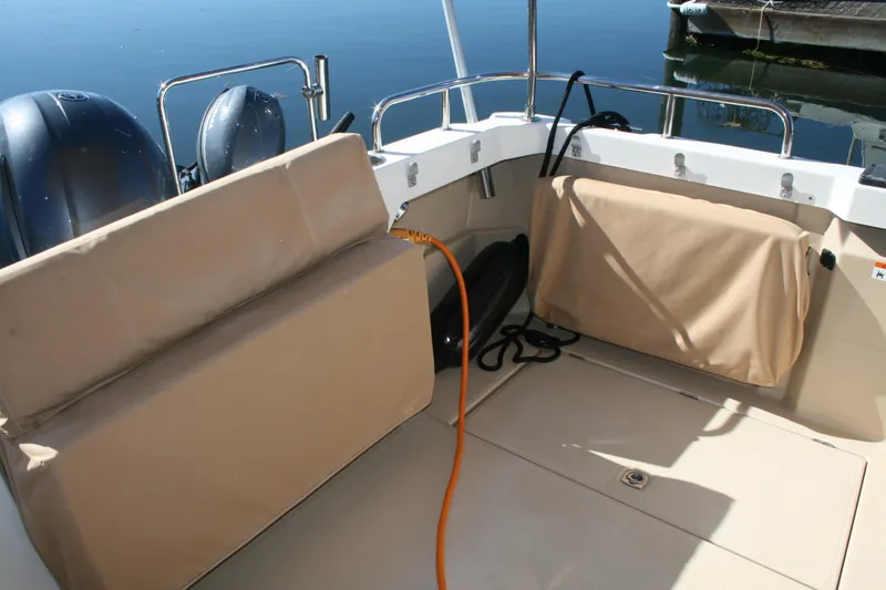 Slide: The Image of 2018 Ranger Tugs R-23 boat interior with cushioned seating and dual outboard motors. - 30