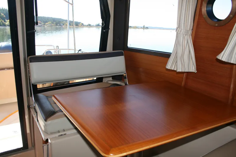 Slide: The Image of Interior of 2018 Ranger Tugs R-23 boat with wooden table and window view. - 9