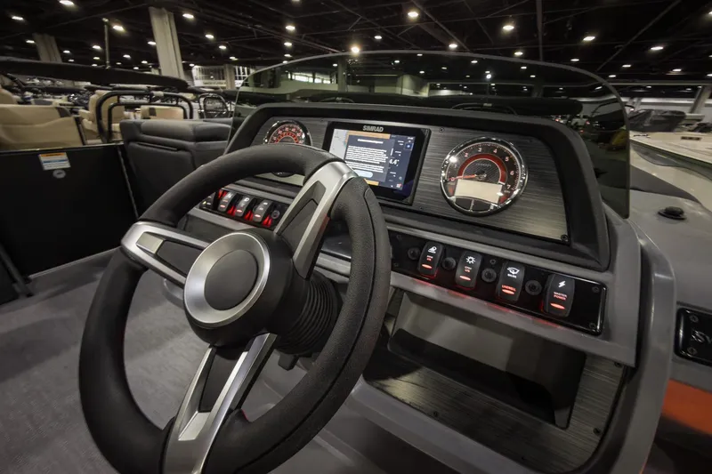 Slide: The Image of 2026 Godfrey Sweetwater 22' Tritoon dashboard with steering wheel and control panel. - 12