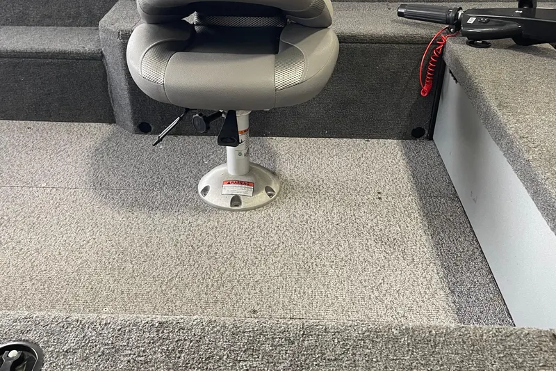 Slide: The Image of 2018 Alumacraft Classic 165 CS boat interior with gray seating and carpeted flooring. - 16