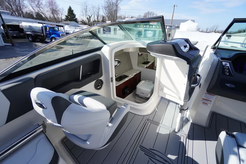 Slide: The Image of 2026 Chaparral 250 OSX boat interior with seating, helm, and cabin area. - 24