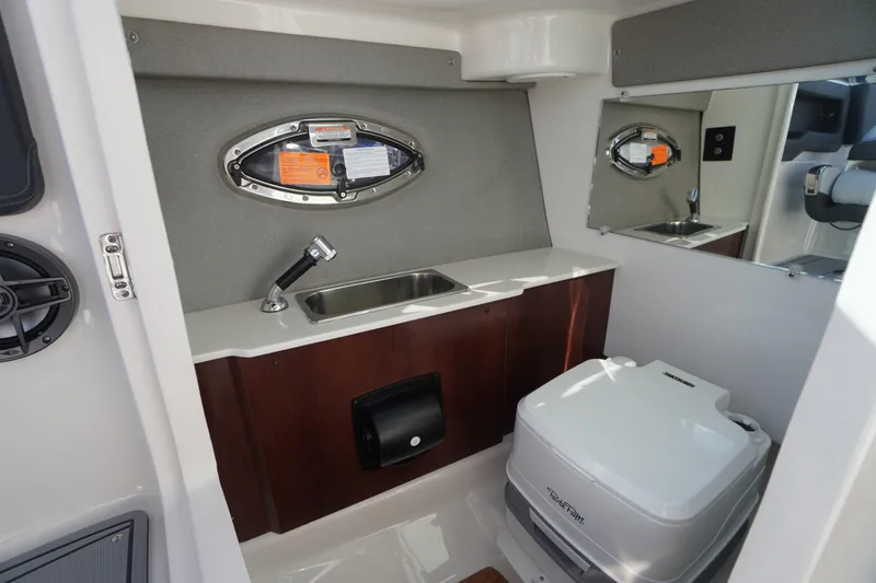 Slide: The Image of 2026 Chaparral 250 OSX boat interior with sink and portable toilet. - 26