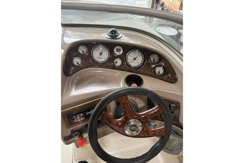 Slide: The Image of Dashboard of a 2002 Regal 2100 LSR boat with gauges and steering wheel. - 5