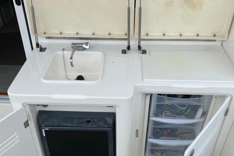 Slide: The Image of 2007 Silverton 36 Convertible yacht kitchenette with sink, storage, and mini fridge. - 12