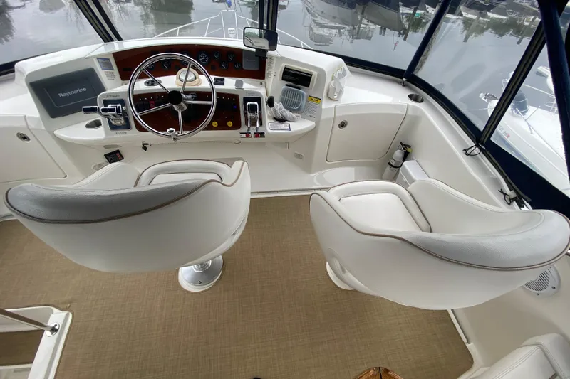 Slide: The Image of 2007 Silverton 36 Convertible yacht cockpit with steering wheel and white captain chairs. - 16