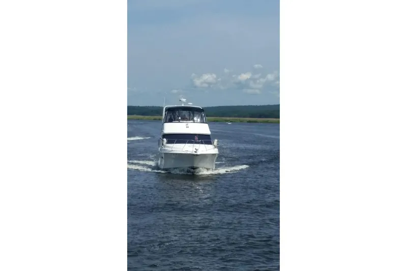 Slide: The Image of 2007 Silverton 36 Convertible boat cruising on a calm waterway. - 2