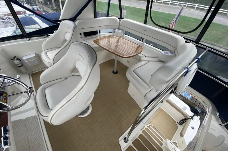 Slide: The Image of 2007 Silverton 36 Convertible yacht interior with white seating and wooden table. - 20