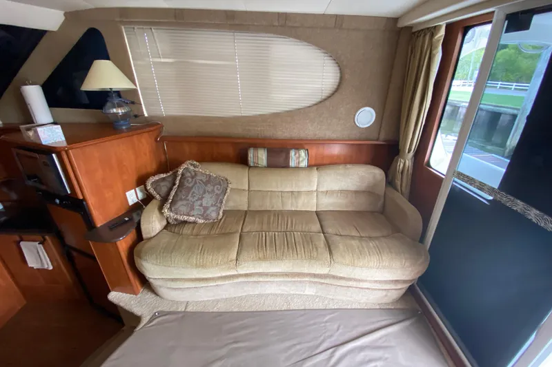 Slide: The Image of Interior of 2007 Silverton 36 Convertible yacht with beige sofa and wooden cabinetry. - 24