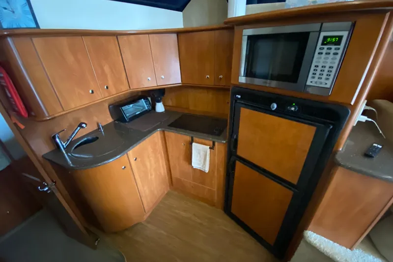 Slide: The Image of 2007 Silverton 36 Convertible yacht kitchen with wood cabinets, sink, microwave, and refrigerator. - 31