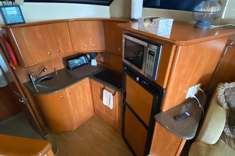 Slide: The Image of 2007 Silverton 36 Convertible yacht kitchen with wood cabinetry, sink, microwave, and appliances. - 32
