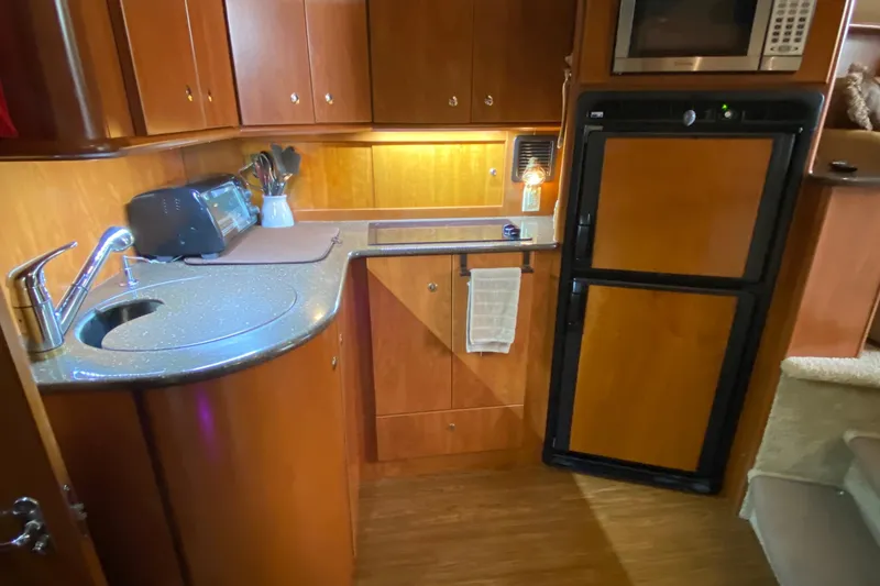Slide: The Image of 2007 Silverton 36 Convertible yacht kitchen with wood cabinetry, sink, and appliances. - 33