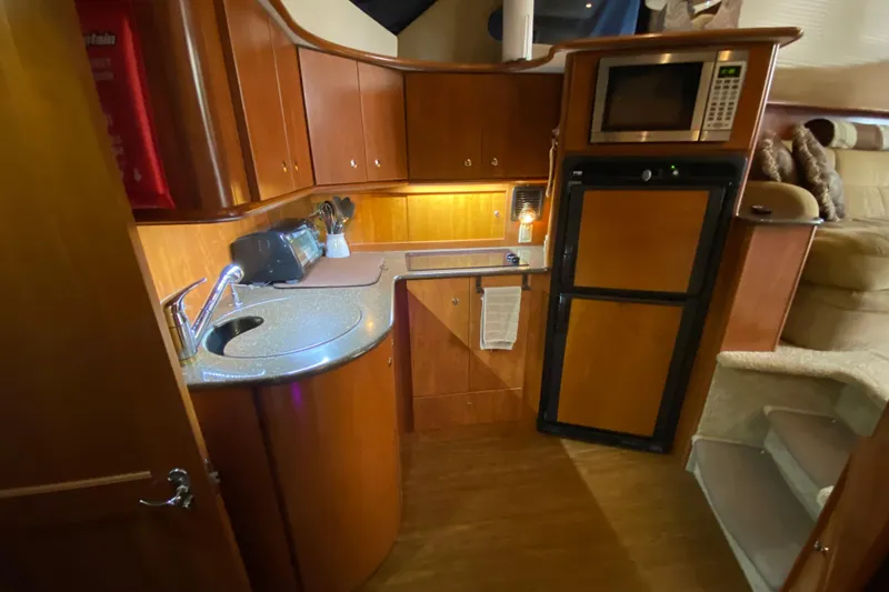 Slide: The Image of 2007 Silverton 36 Convertible yacht kitchen with wood cabinetry, sink, and appliances. - 34