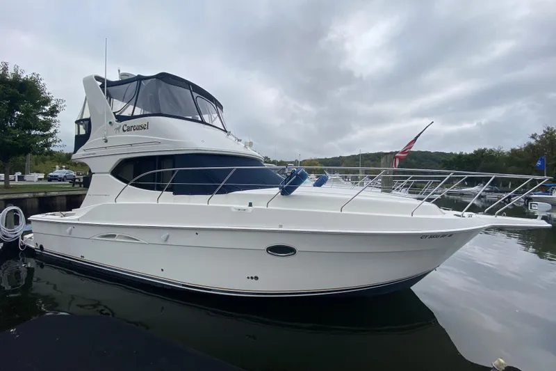 Slide: The Image of 2007 Silverton 36 Convertible yacht docked, featuring sleek design and American flag. - 4