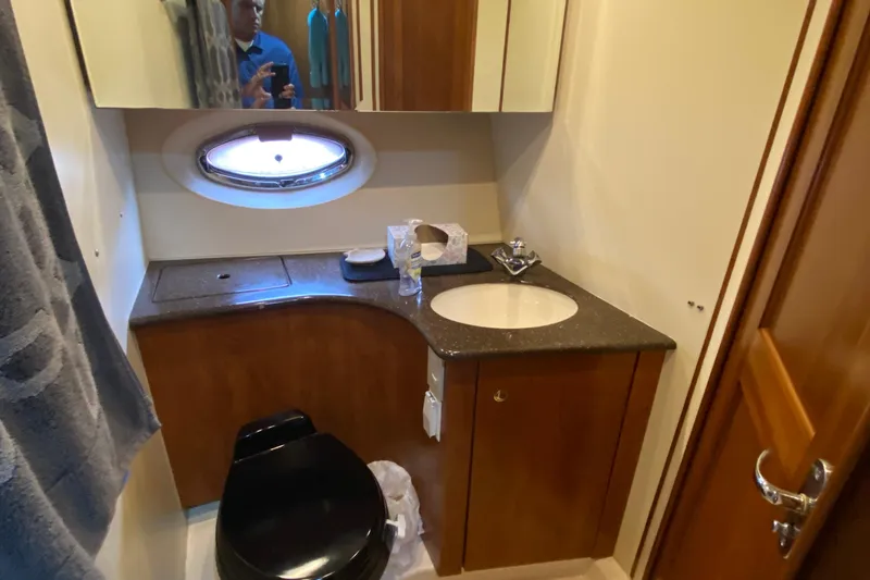 Slide: The Image of 2007 Silverton 36 Convertible yacht bathroom with sink, mirror, and porthole window. - 41