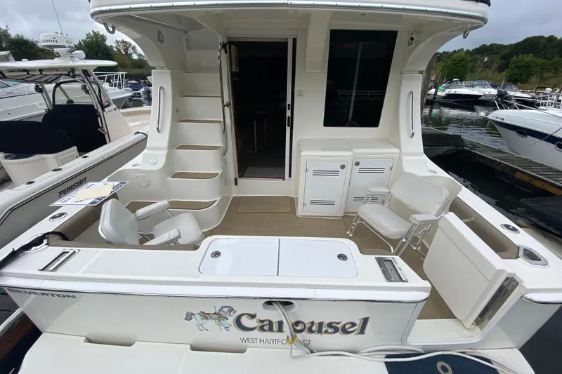 Slide: The Image of 2007 Silverton 36 Convertible boat with spacious deck and seating at a marina. - 8