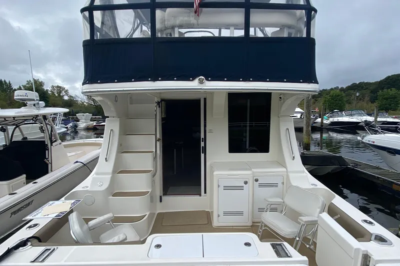 Slide: The Image of 2007 Silverton 36 Convertible yacht docked, featuring spacious deck and upper helm area. - 9