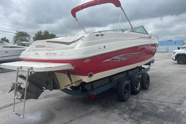 Slide: The Image of 2008 Rinker 282 Captiva Cuddy boat on trailer, red and white exterior, overcast sky. - 2