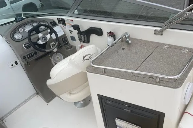 Slide: The Image of 2008 Rinker 282 Captiva Cuddy boat interior with helm and kitchenette area. - 6