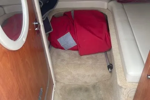 Slide: The Image of 2008 Rinker 282 Captiva Cuddy cabin interior with red life jacket on carpeted floor. - 8