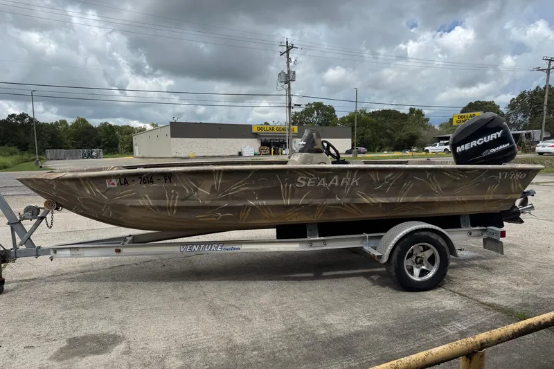 The Image of 2011 SeaArk XV180 CC boat on trailer with Mercury outboard motor, parked outdoors. - 10