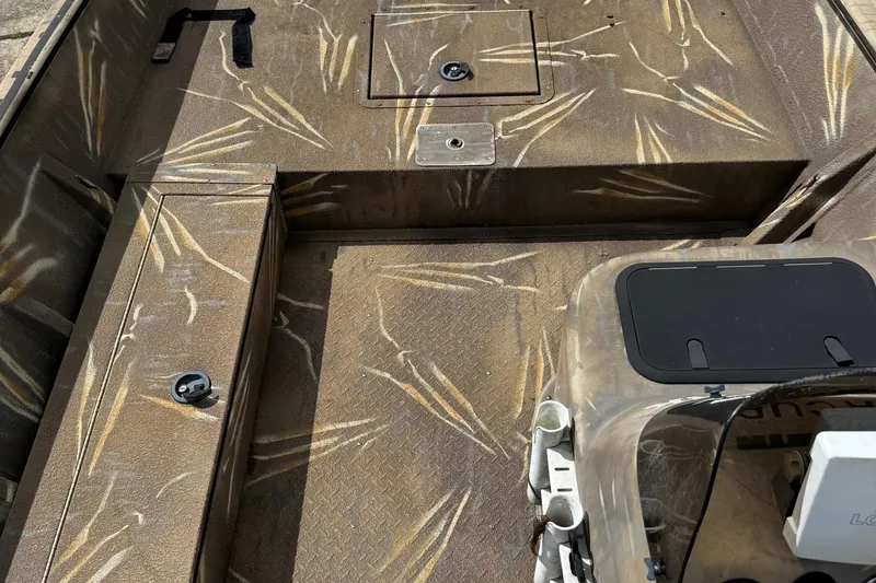 Slide: The Image of 2011 SeaArk XV180 CC boat interior with camouflage pattern and storage compartments. - 15