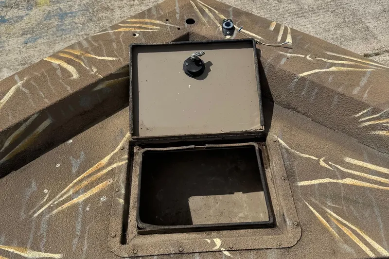 Slide: The Image of Open storage compartment on 2011 SeaArk XV180 CC boat with camouflage pattern. - 17