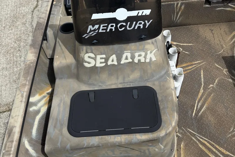 Slide: The Image of 2011 SeaArk XV180 CC boat with Mercury branding, camo design, and storage compartment. - 18
