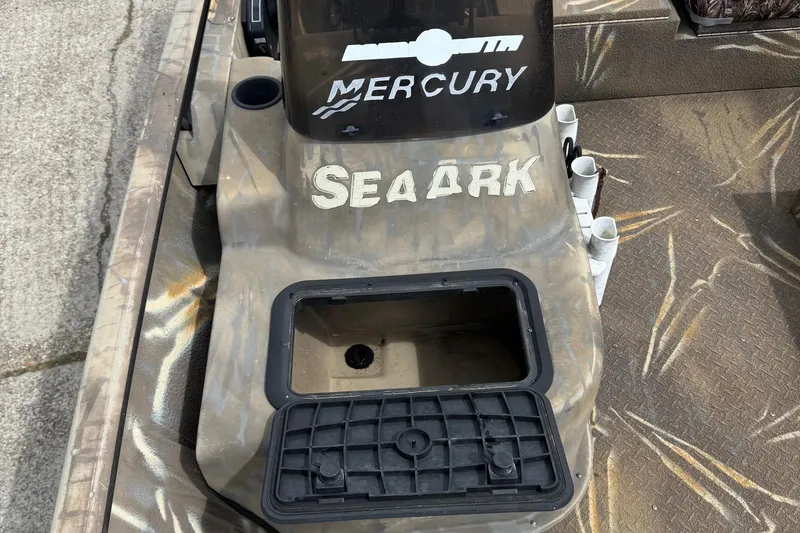 Slide: The Image of 2011 SeaArk XV180 CC boat with Mercury engine, camo design, and storage compartment. - 19
