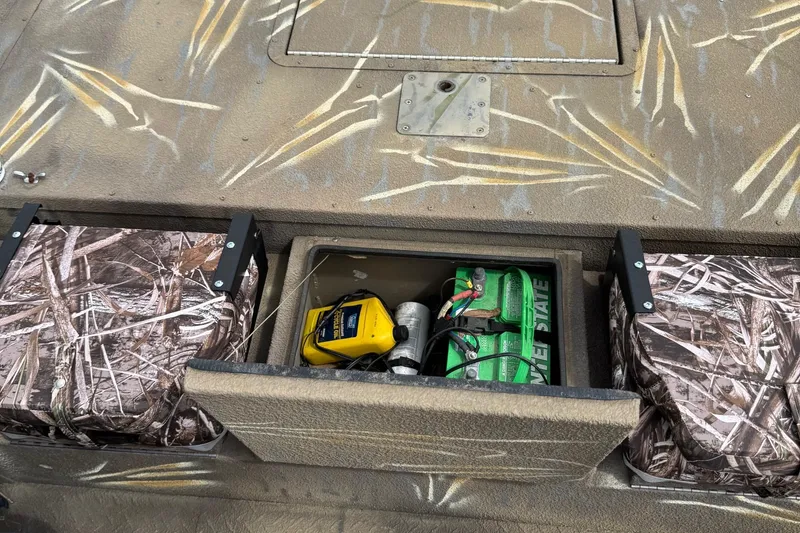 Slide: The Image of 2011 SeaArk XV180 CC boat interior with camo seats and battery compartment. - 20