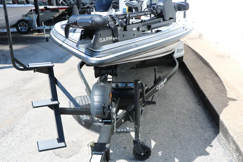 Slide: The Image of 2025 Caymas CX 21 PRO boat on trailer with Garmin equipment, parked outdoors. - 13