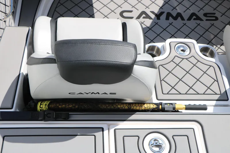 Slide: The Image of 2025 Caymas CX 21 PRO boat interior with cushioned seat and fishing rod storage. - 33