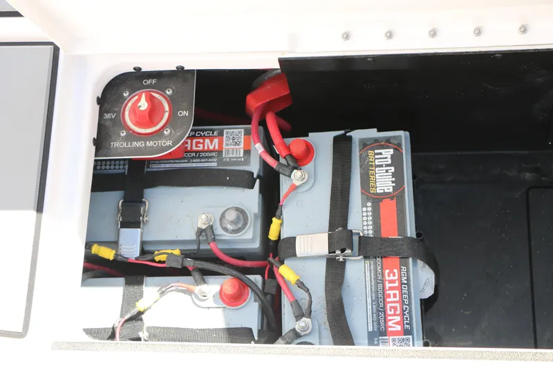 Slide: The Image of 2025 Caymas CX 21 PRO boat battery compartment with AGM deep cycle batteries and trolling motor switch. - 41