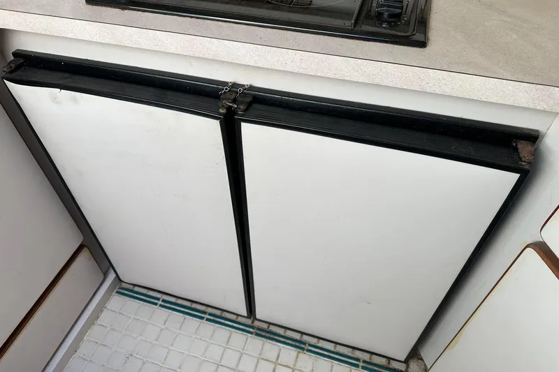 Slide: The Image of 1992 Regal Commodore 400 kitchen cabinet with white doors and black trim. - 11