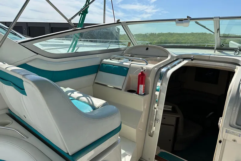 Slide: The Image of 1992 Regal Commodore 400 boat interior with white and teal seating, open cabin door, and fire extinguisher. - 16