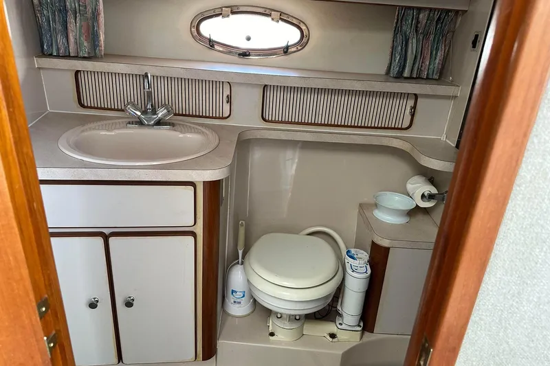Slide: The Image of 1992 Regal Commodore 400 boat bathroom with sink, toilet, and porthole window. - 17