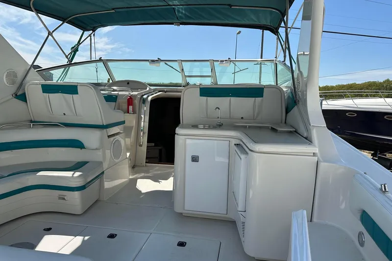 Slide: The Image of 1992 Regal Commodore 400 boat interior with seating, kitchenette, and helm under a canopy. - 19