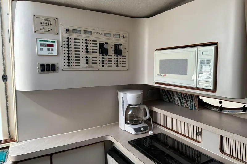 Slide: The Image of 1992 Regal Commodore 400 yacht kitchen with control panel, microwave, coffee maker, and stove. - 25