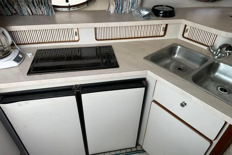 Slide: The Image of 1992 Regal Commodore 400 kitchen with stove, sink, and cabinets. - 26