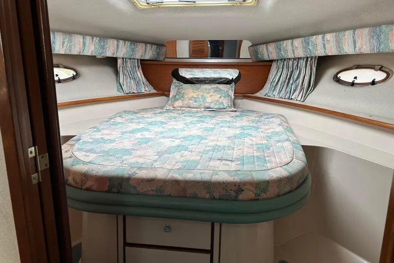 Slide: The Image of Cozy cabin interior of 1992 Regal Commodore 400 with floral bedding and porthole windows. - 3