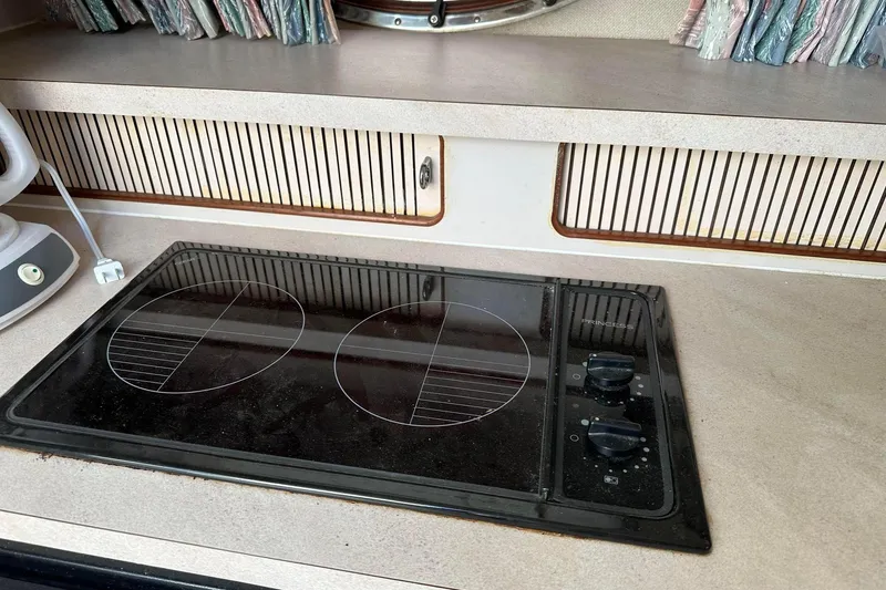 Slide: The Image of 1992 Regal Commodore 400 kitchen with electric stovetop and retro design elements. - 7
