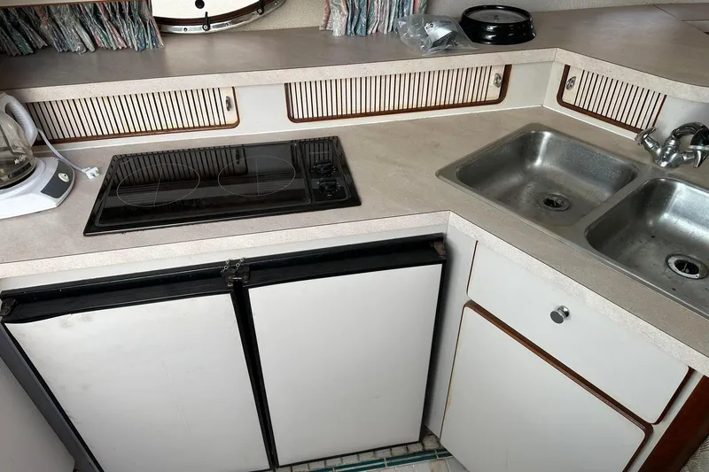 Slide: The Image of 1992 Regal Commodore 400 kitchen with stove, double sink, and white cabinetry. - 9